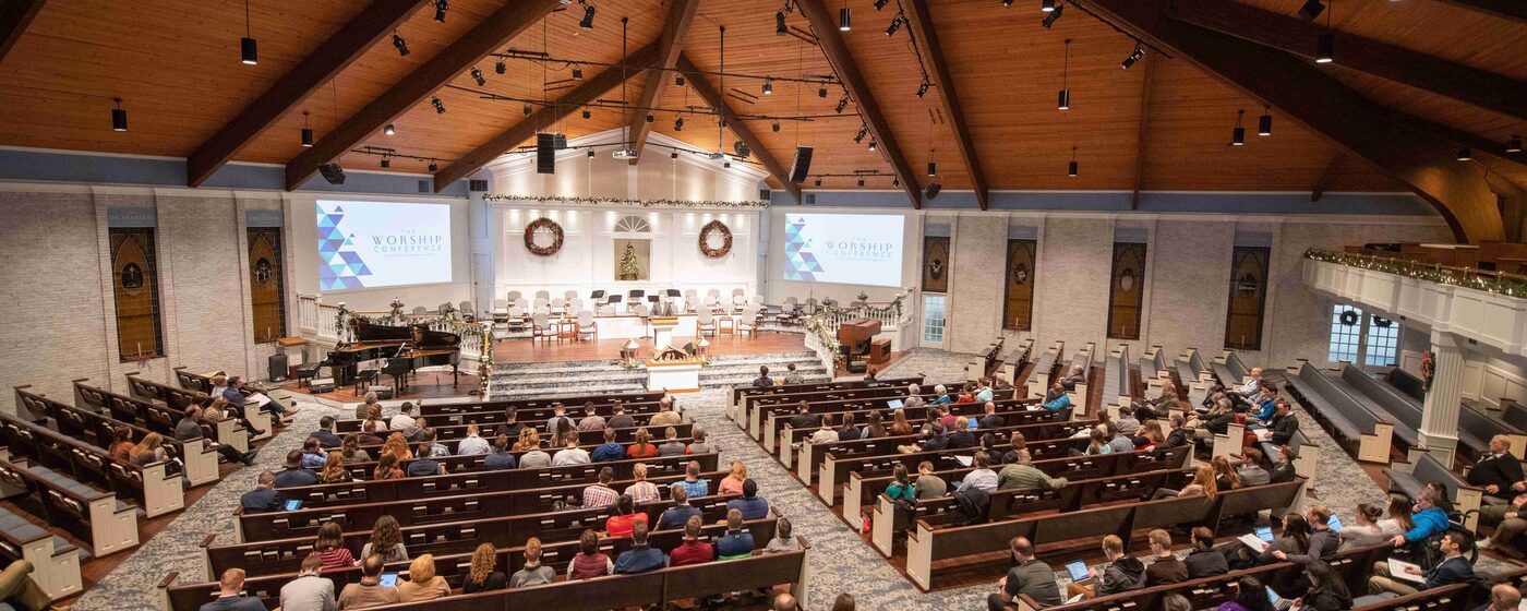 Church sanctuary interior with wooden pews and timber ceiling