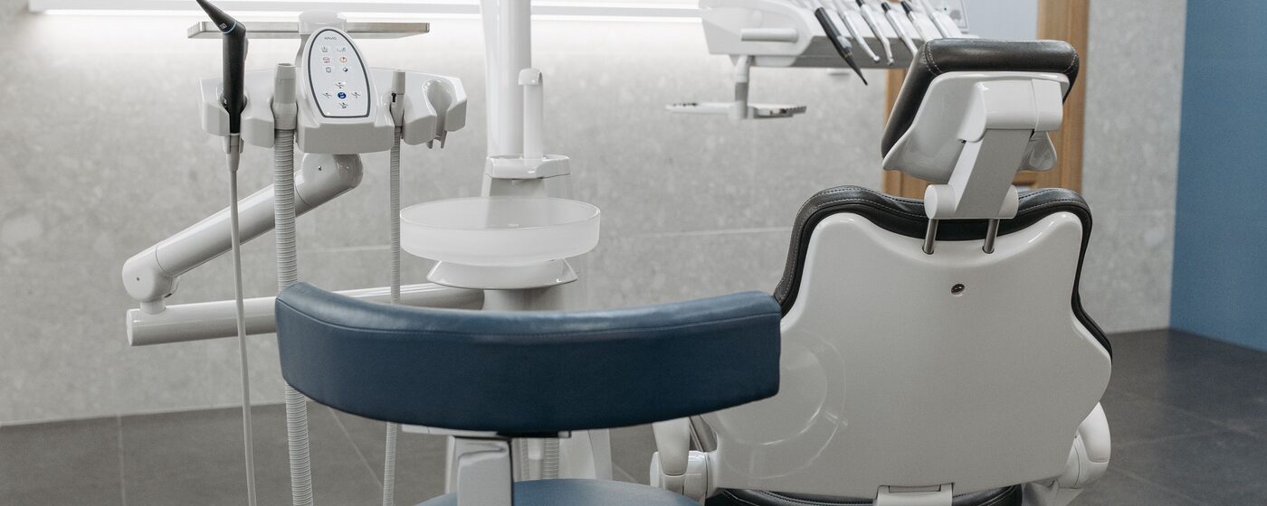 Dental exam room with a treatment chair and overhead equipment