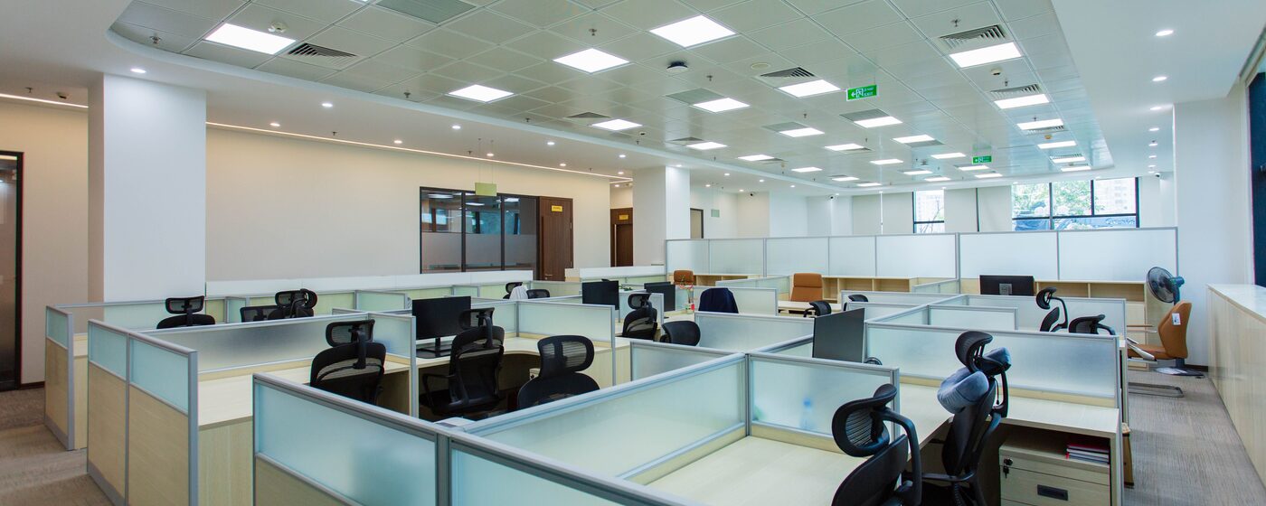 Open-plan corporate office floor with rows of cubicles and workstations