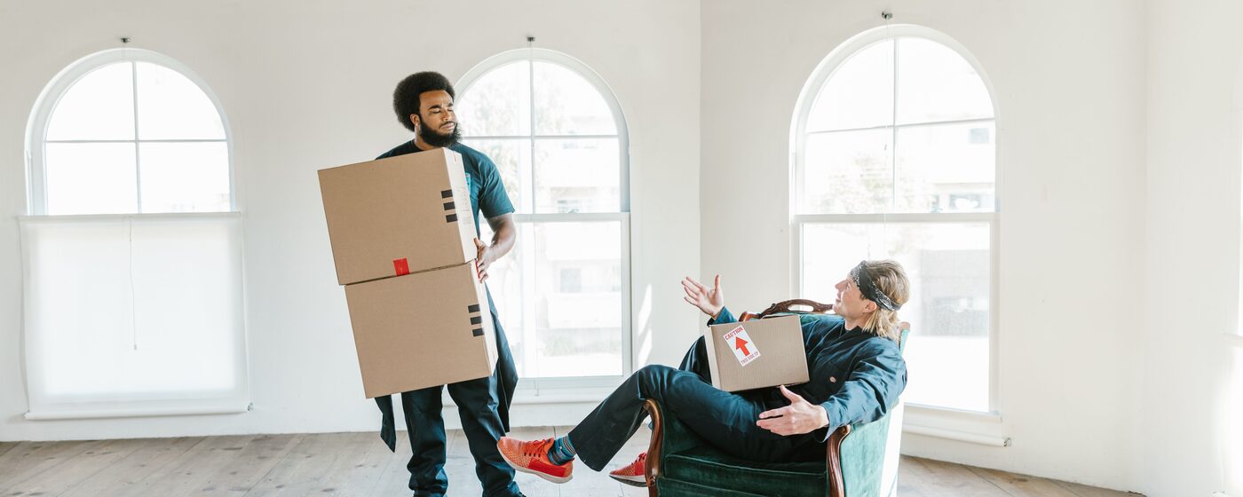 Movers carrying boxes through an empty room during a move
