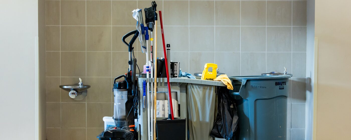 Janitorial cleaning cart stocked with supplies in an office hallway