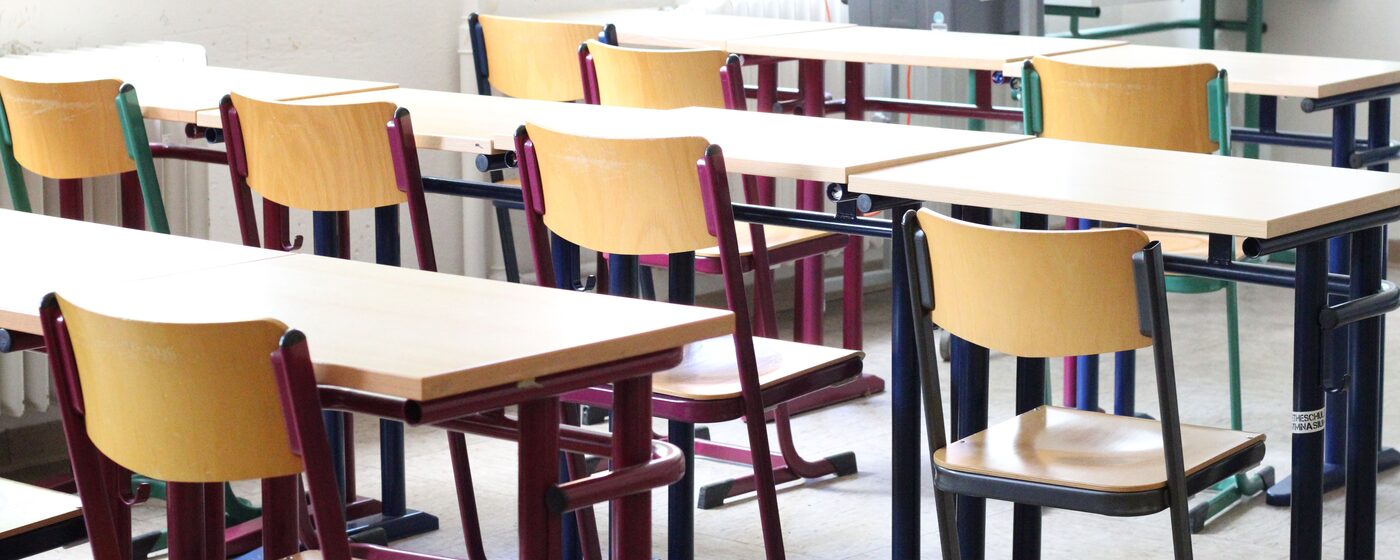 Empty school classroom with rows of desks and chairs